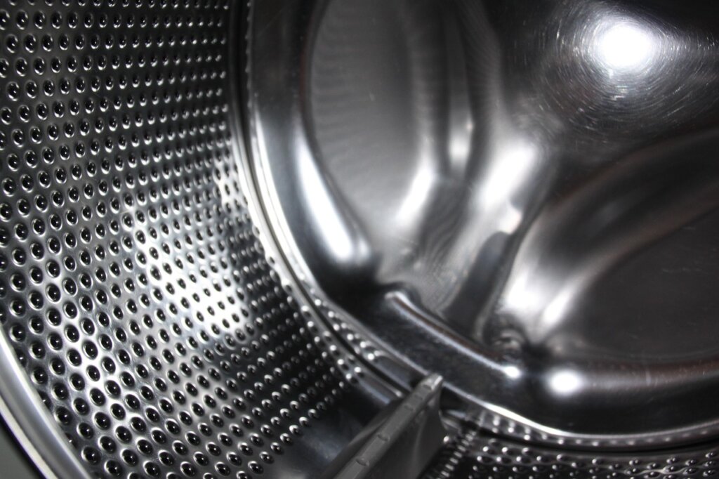 washing machine drum black mold residue floating in water