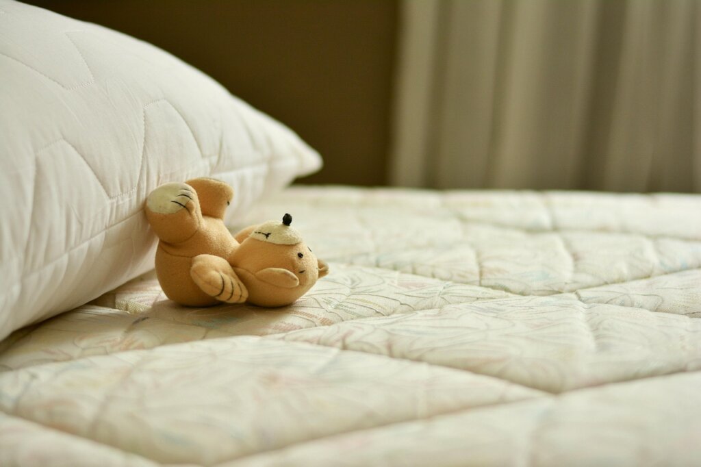 waterproof mattress protector being placed on bed