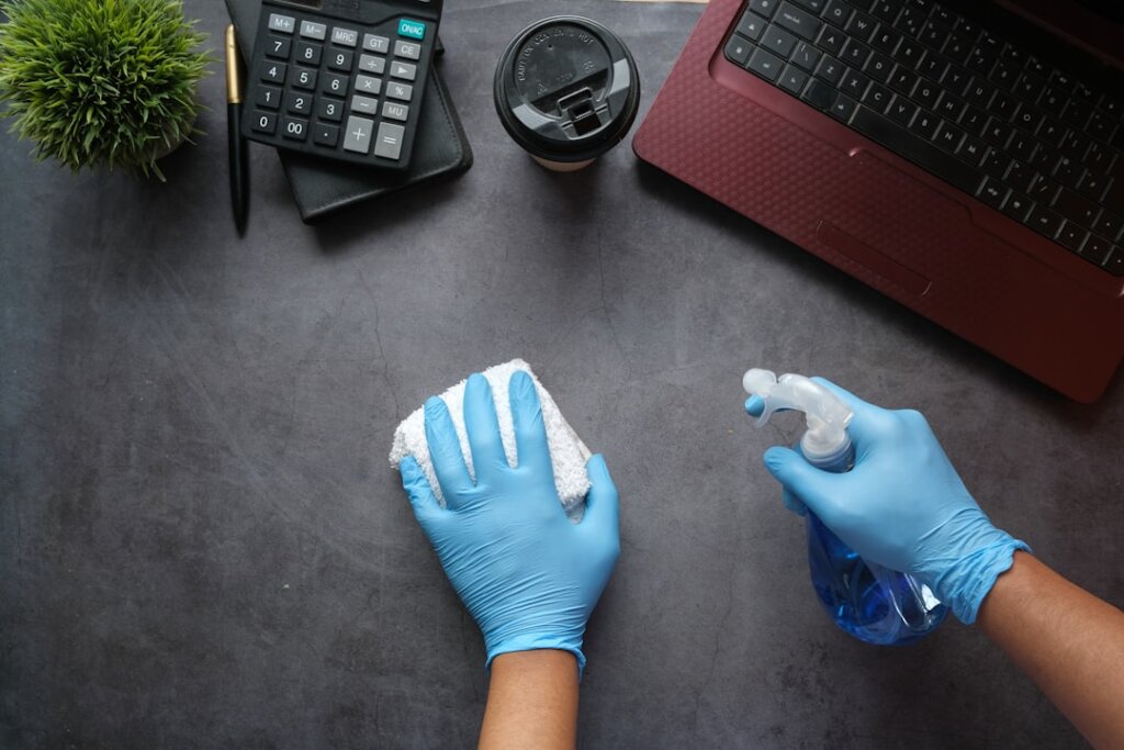 comparison table of wallpaper cleaning methods displayed on a desk with cleaning supplies arranged neatly
