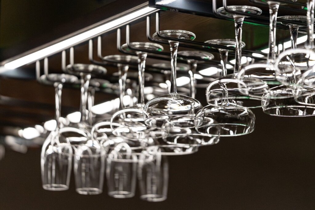 clean white kitchen towel hanging open on stainless steel rack near window with sunlight